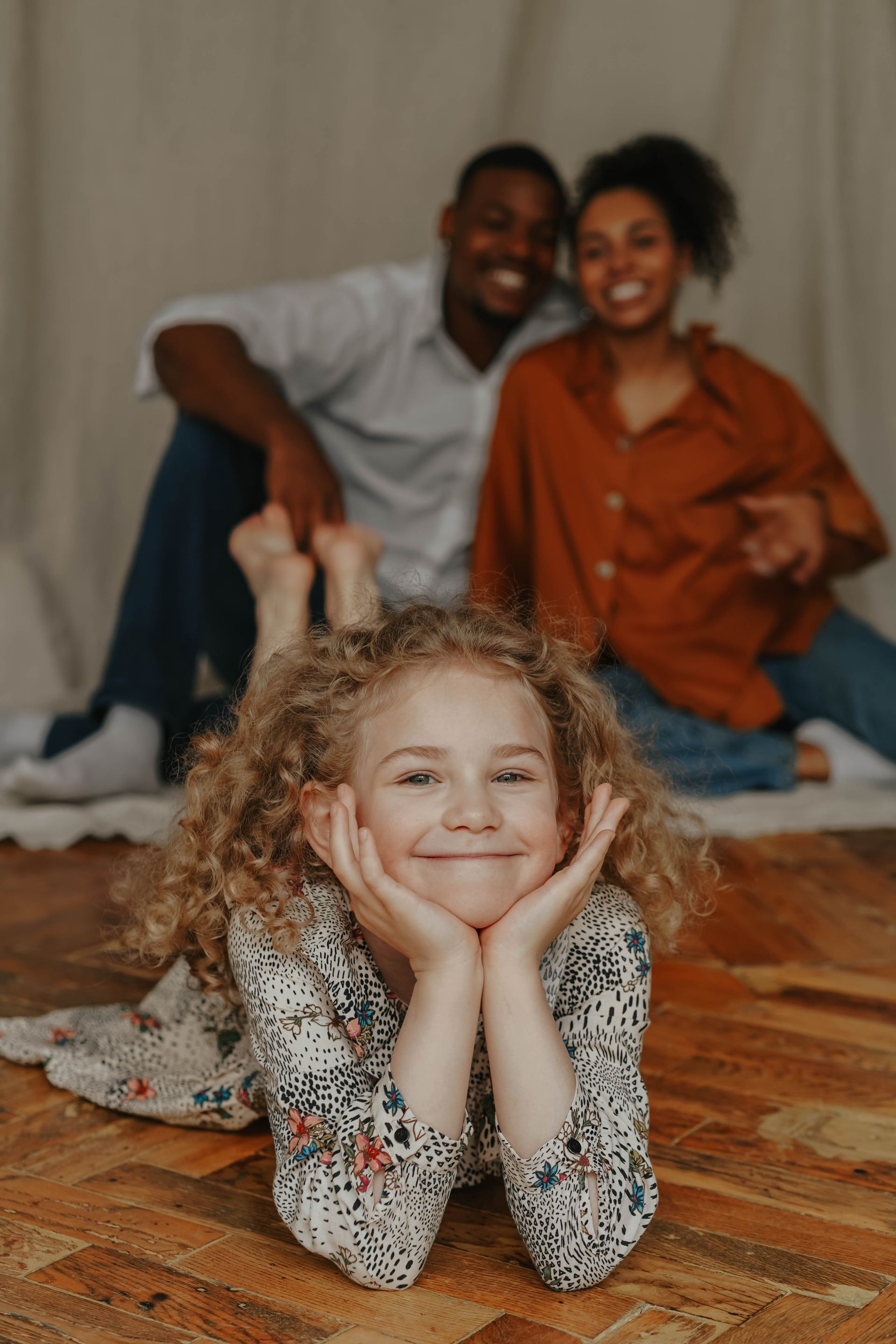 A smiling young girl with her parents at home
